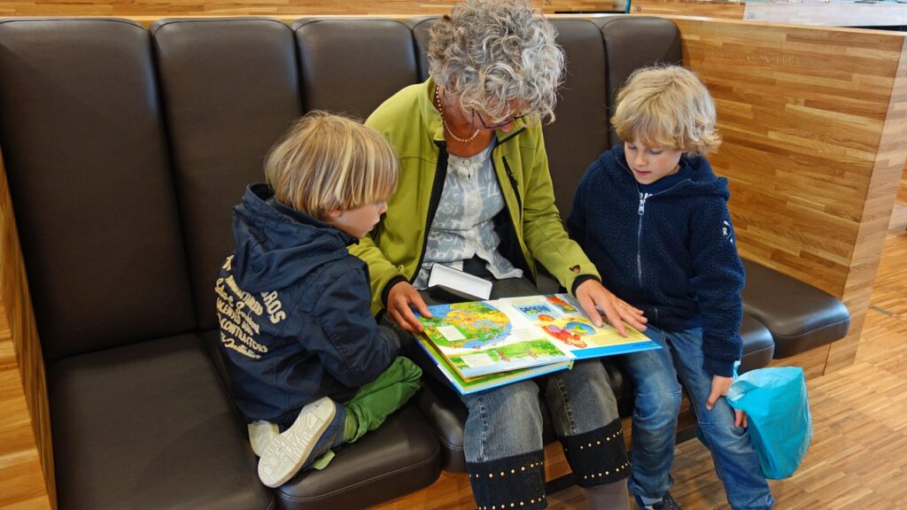 Babcia czyta wnukom książeczkę w czytelni Gręboszów